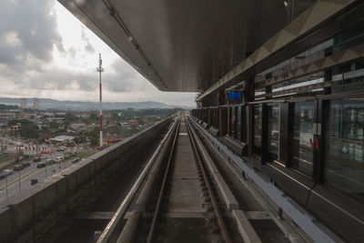 Railroad tracks in city against sky
