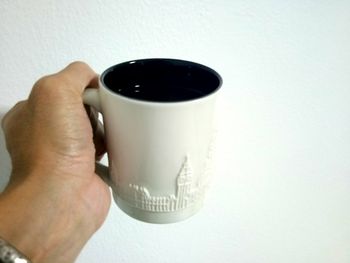 Cropped image of hand holding coffee cup