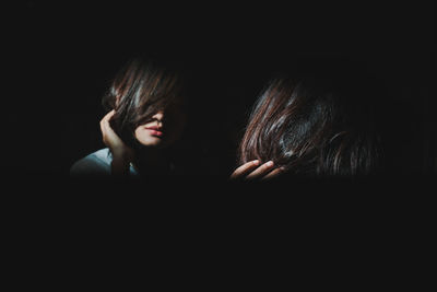 Close-up portrait of two people in black background