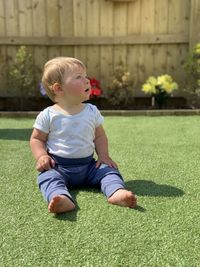 Portrait of cute boy playing with ball on grass