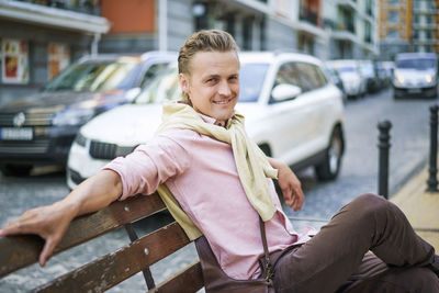 Young woman using mobile phone while sitting on bench