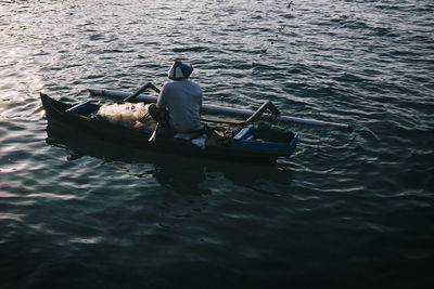 Rear view of man in boat sailing on sea