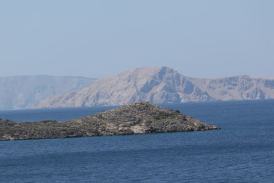 Scenic view of sea and mountains against clear sky