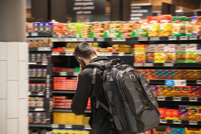 Rear view of man standing at store