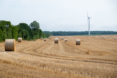 Hay bales on field against sky