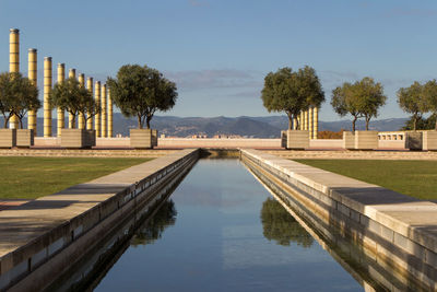 Swimming pool by lake against sky