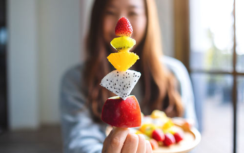 Close-up of woman having fruits at home