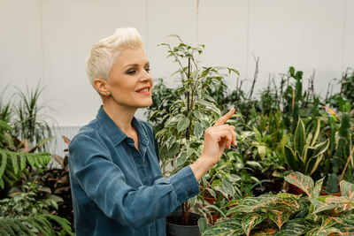 Caucasian happy woman enjoy planting indoor space.home garden.