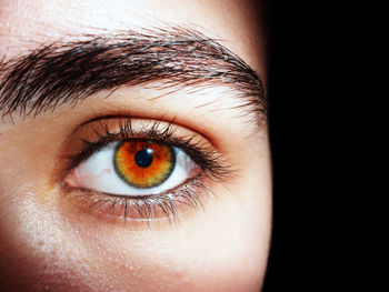 Cropped portrait of woman against black background