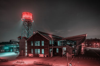 Illuminated buildings against sky at night