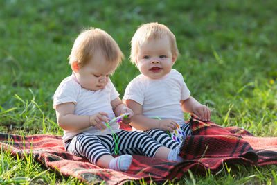 Cute boy sitting on field