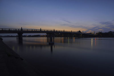 Bridge over river against sky during sunset