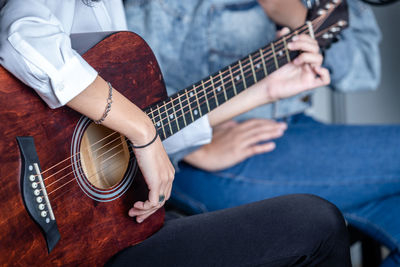 Midsection of man playing guitar