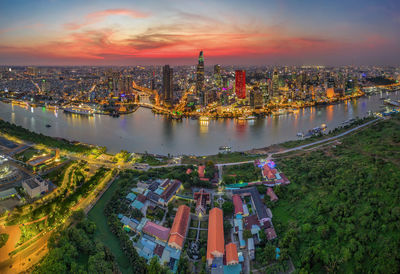 High angle view of river amidst buildings against sky during sunset