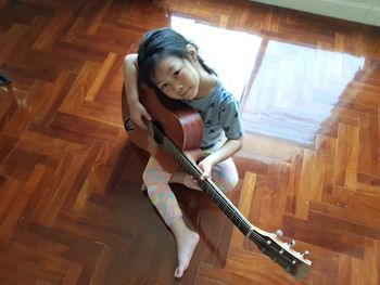 Girl playing on wooden floor at home
