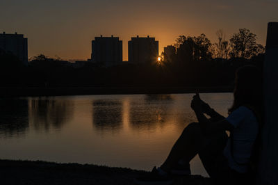 Teenage girl sitting at lakeshore 