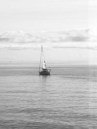 Sailboat sailing on sea against sky