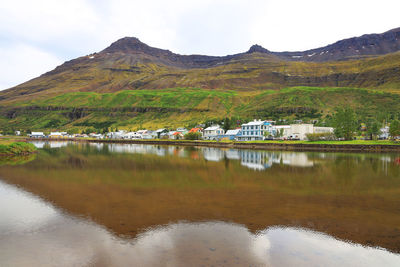 Reflection of houses in lake against mountains