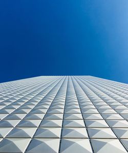 Low angle view of modern building against blue sky