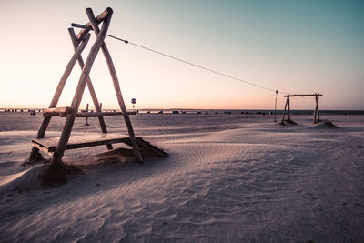 Scenic view of beach against clear sky during sunset