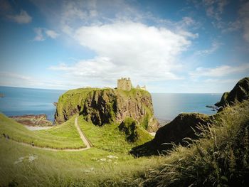 Dunnottar castle by sea against sky