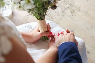 Cropped image of newlywed couple holding hands