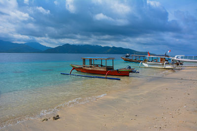 Boat in sea against cloudy sky