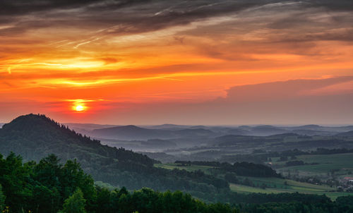 Scenic view of landscape against orange sky