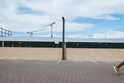 Man standing by railing against sky