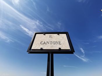 Low angle view of road sign against blue sky