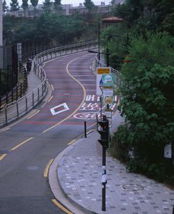 Empty road along trees and plants in city