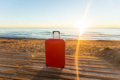 Tea light on beach against sky during sunset