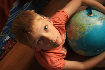 High angle view of boy playing with the globe