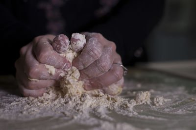 Cropped hands of woman kneading dough