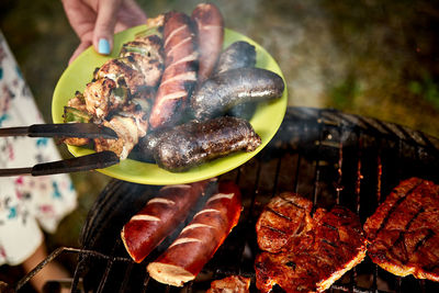 Close-up of person hand on barbecue