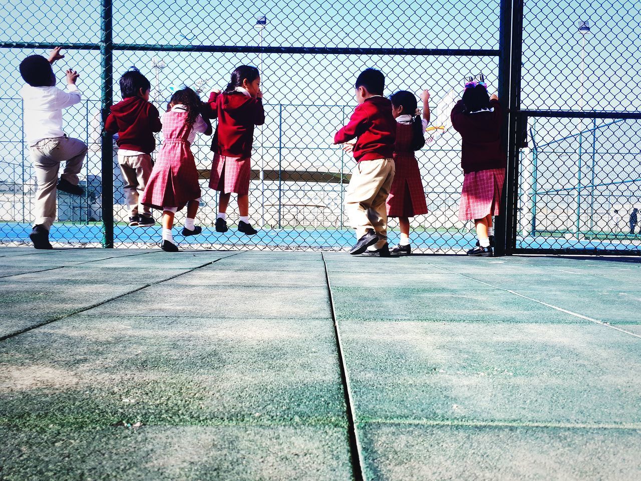 GROUP OF PEOPLE PLAYING WITH FENCE