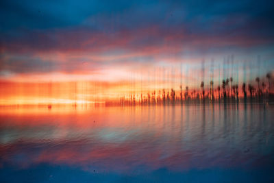 Scenic view of lake against sky at sunset