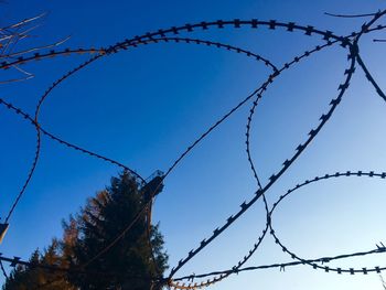 Low angle view of barbed wire against clear sky