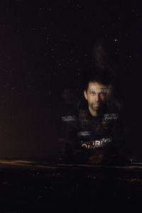 Portrait of young man against black background