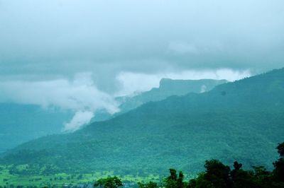 Scenic view of mountains against cloudy sky