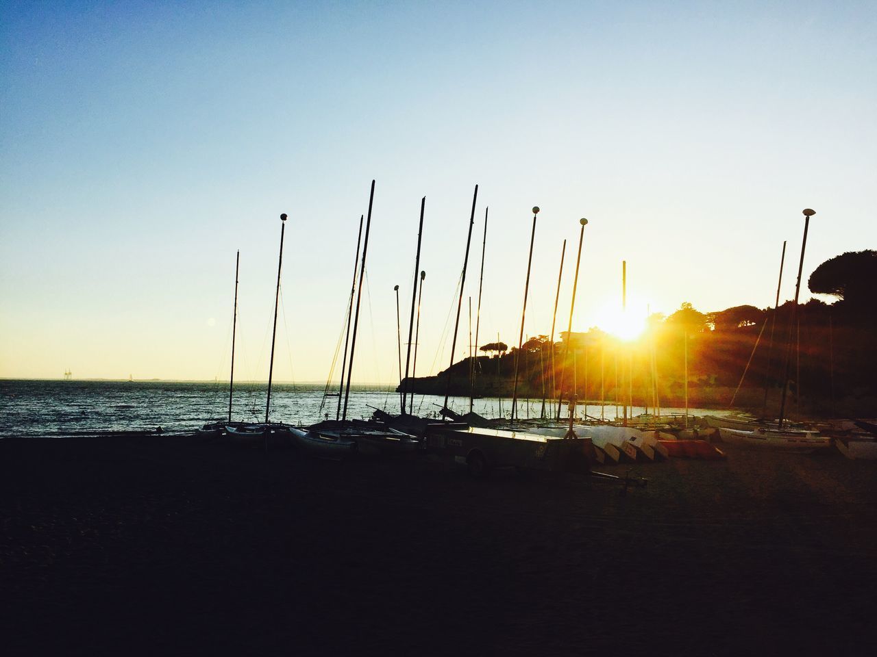 sea, sun, water, sunset, beach, horizon over water, shore, scenics, silhouette, tranquil scene, tranquility, beauty in nature, clear sky, sunlight, nature, sky, idyllic, copy space, sunbeam, incidental people