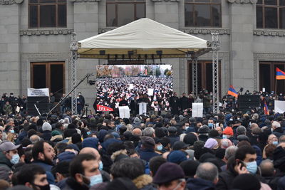 Group of people on street against buildings in city