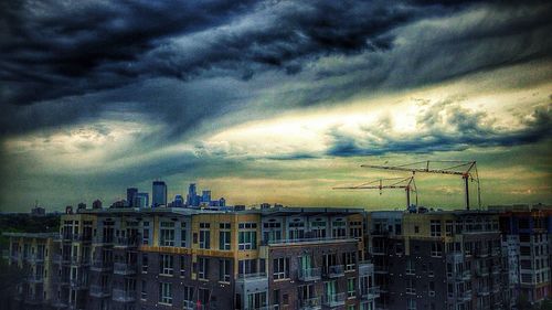 Buildings against cloudy sky at sunset