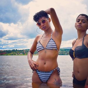 Young women standing in sea against sky