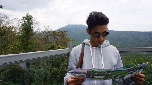 Young man in mountains against sky