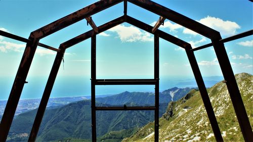 Scenic view of mountains seen through metal window frame