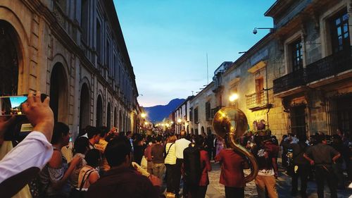 People on street amidst buildings in city