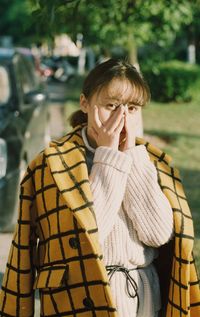 Portrait of woman covering face with hands