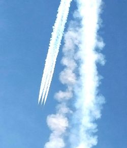 Low angle view of airplane flying against blue sky