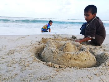 Male friends playing at beach